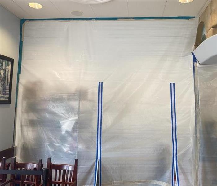 Plastic wall containment set up at a business during water mitigation