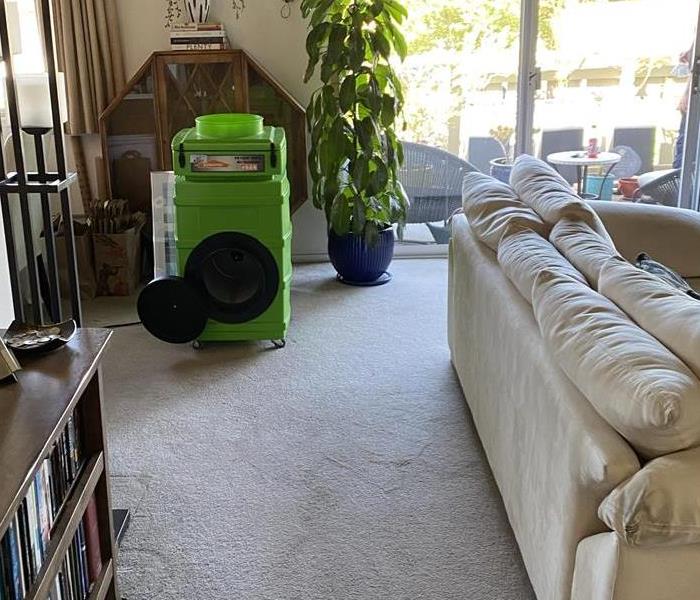 Green air scrubber in a living room placed for smoke remediation